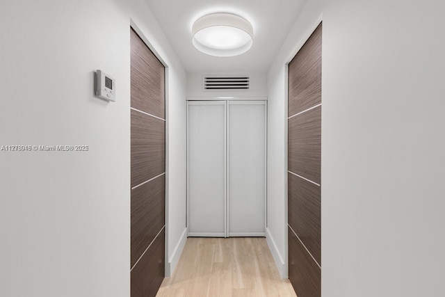 hall featuring visible vents and wood finished floors