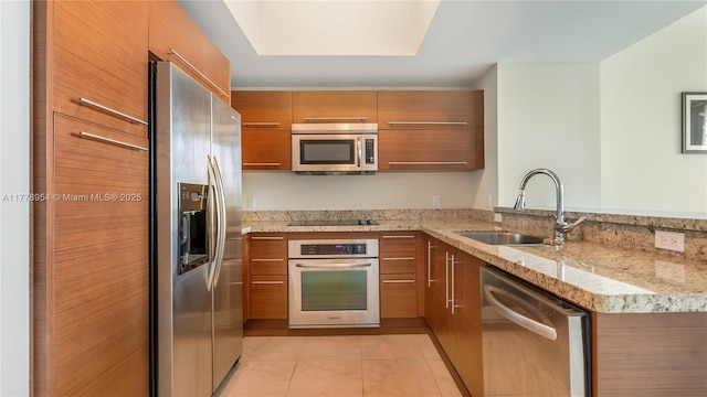 2681 N Flamingo Rd Unit 306S, Sunrise, FL 33323 - kitchen with stainless steel appliances, brown cabinetry, a peninsula, and light tile patterned floors