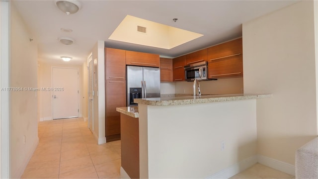 2681 N Flamingo Rd Unit 306S, Sunrise, FL 33323 - kitchen with appliances with stainless steel finishes, brown cabinetry, a peninsula, light tile patterned floors, and light stone counters