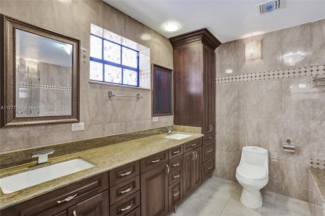full bath with visible vents, tile walls, and a sink