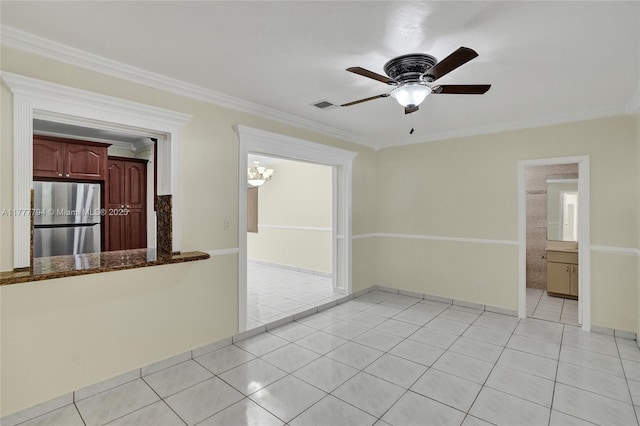 spare room with light tile patterned flooring, ceiling fan, ornamental molding, and visible vents