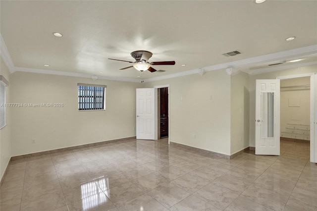 spare room with ceiling fan, baseboards, ornamental molding, and visible vents