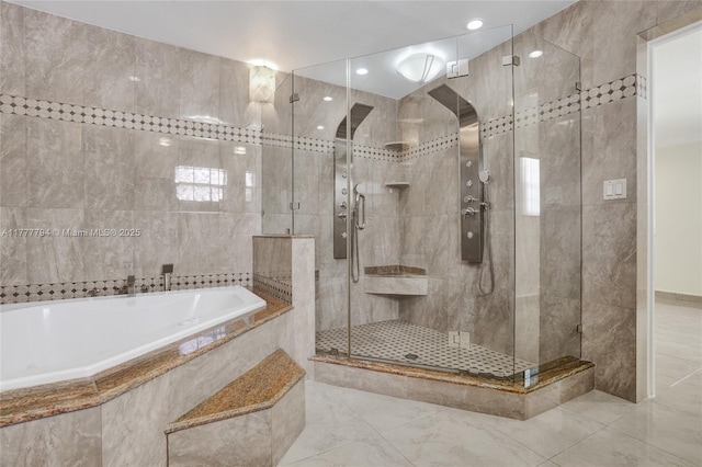 bathroom featuring a stall shower, a garden tub, and tile walls