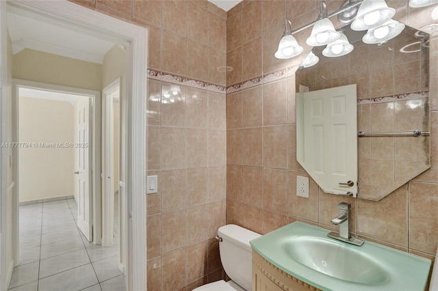bathroom featuring toilet, vanity, tile patterned flooring, and tile walls
