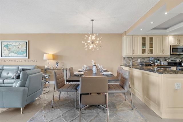 dining area featuring an inviting chandelier, a tray ceiling, and recessed lighting