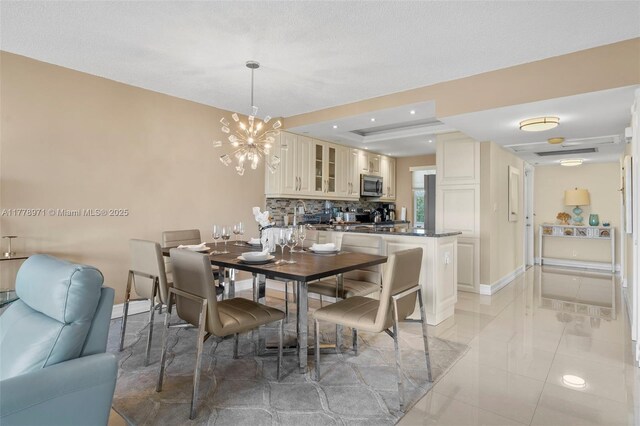 dining area featuring recessed lighting, a notable chandelier, a tray ceiling, and baseboards