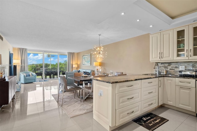 kitchen with a sink, open floor plan, backsplash, and floor to ceiling windows