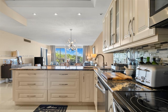 kitchen featuring a sink, open floor plan, stainless steel appliances, a peninsula, and visible vents