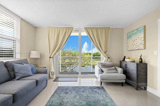 tiled living room with a textured ceiling and baseboards