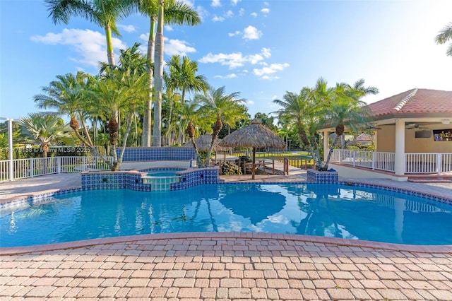 view of pool featuring a gazebo, fence, a ceiling fan, and a pool with connected hot tub