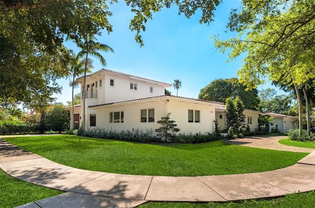view of home's exterior featuring a yard, a tiled roof, and stucco siding