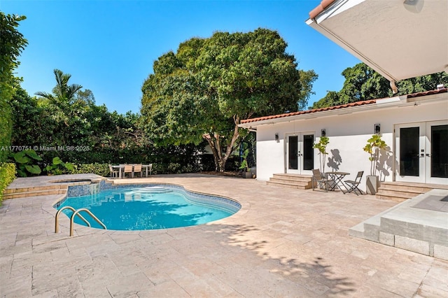 view of swimming pool featuring entry steps, french doors, a patio area, and a pool with connected hot tub