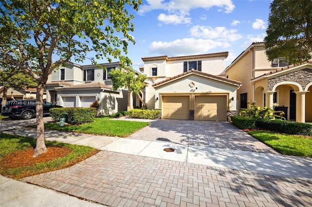view of front of property featuring stucco siding, decorative driveway, an attached garage, and a tile roof