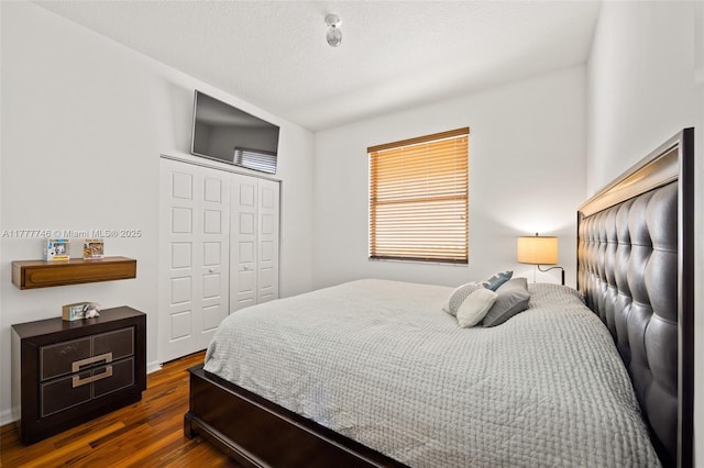 bedroom featuring a textured ceiling, a closet, and dark wood-style flooring