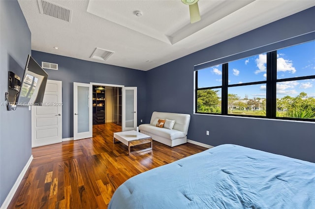 bedroom featuring visible vents, baseboards, and wood finished floors