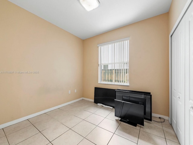 unfurnished room featuring light tile patterned floors and baseboards