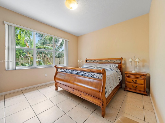 bedroom featuring light tile patterned floors and baseboards
