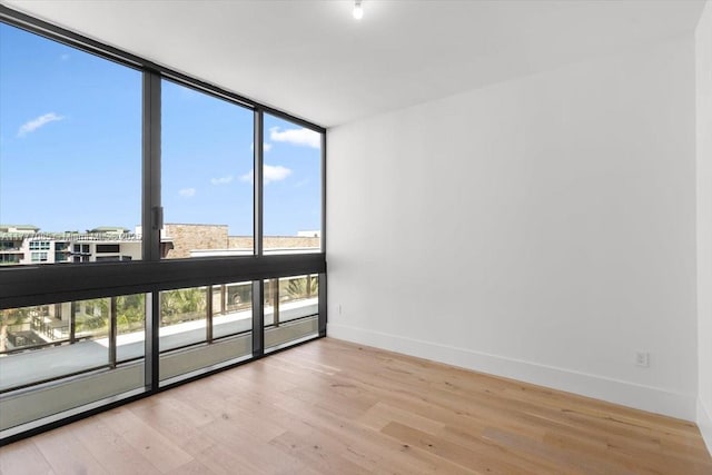160 Isle Of Venice Dr Unit Ph2, Fort Lauderdale, FL 33301 - empty room featuring baseboards, wood finished floors, and expansive windows