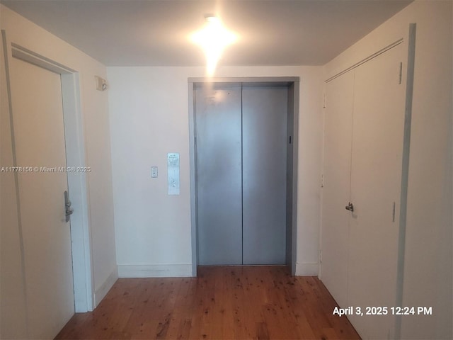 1331 Brickell Bay Dr Unit 2702, Miami, FL 33131 - corridor featuring elevator, wood finished floors, and baseboards