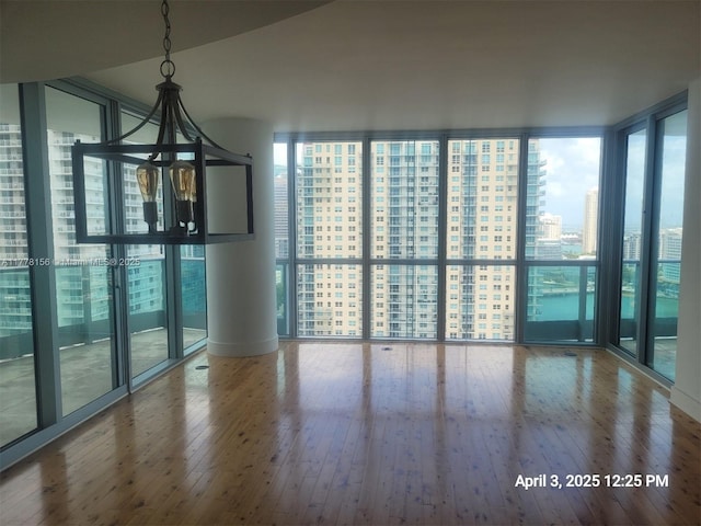 1331 Brickell Bay Dr Unit 2702, Miami, FL 33131 - empty room featuring wood-type flooring, expansive windows, and a city view