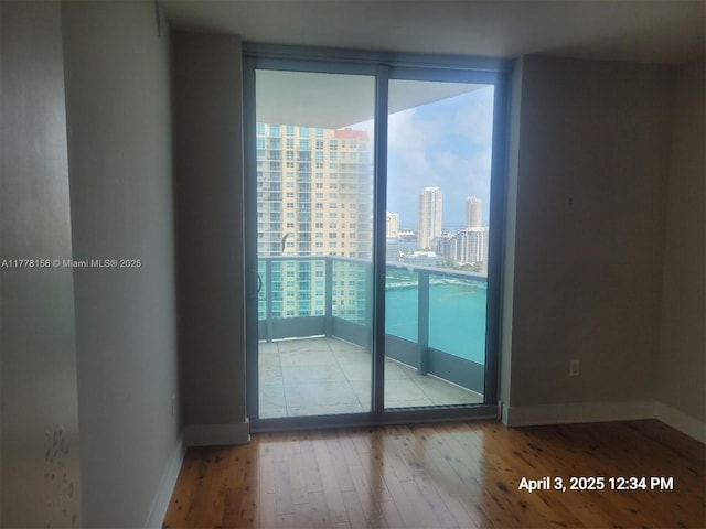 1331 Brickell Bay Dr Unit 2702, Miami, FL 33131 - spare room featuring expansive windows, wood finished floors, a view of city, and baseboards