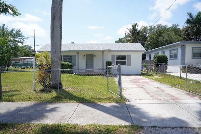ranch-style home with concrete driveway, a front yard, and a fenced front yard