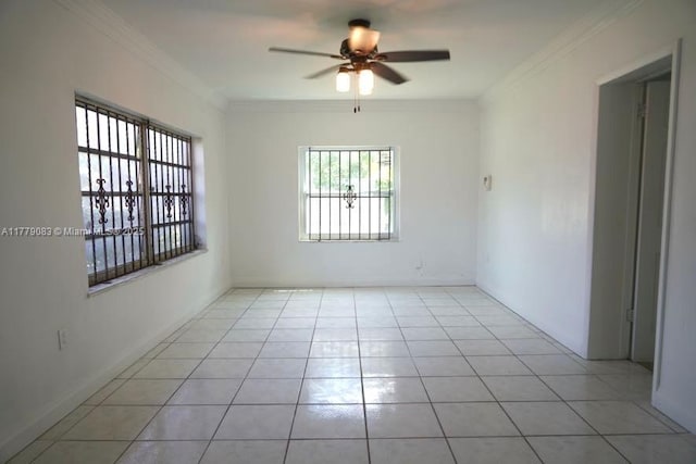 empty room featuring crown molding, light tile patterned floors, baseboards, and a ceiling fan