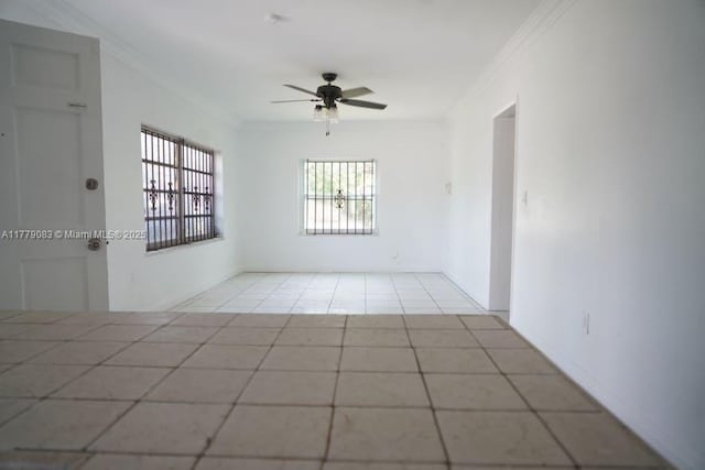 empty room with crown molding, ceiling fan, and tile patterned floors