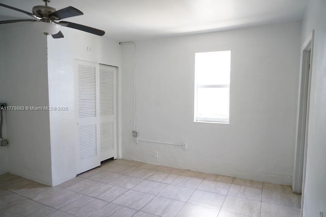 unfurnished bedroom with a closet, ceiling fan, and tile patterned flooring