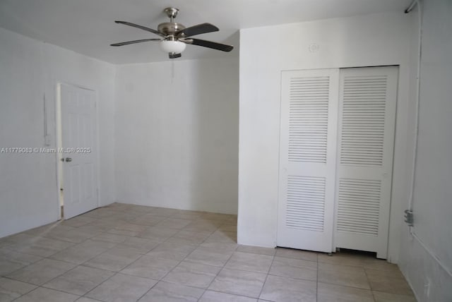 empty room featuring a ceiling fan and light tile patterned flooring