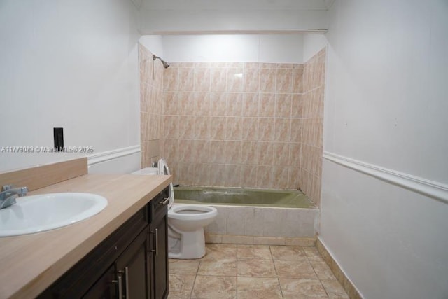 bathroom featuring toilet, tiled shower / bath combo, and vanity