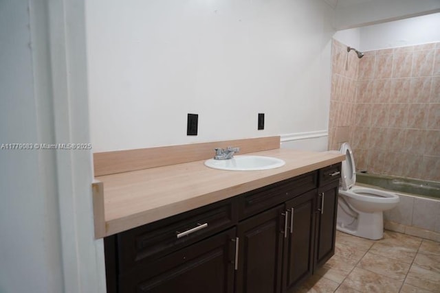 full bath with tiled shower / bath, tile patterned floors, vanity, and toilet