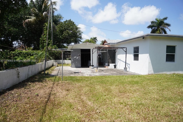 back of property with a patio area, stucco siding, fence, and a lawn
