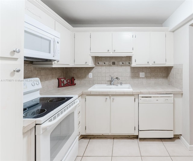 1811 Jefferson St Unit 304, Hollywood, FL 33020 - kitchen featuring white appliances, white cabinets, light tile patterned floors, backsplash, and tile counters
