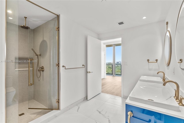 full bathroom featuring a shower stall, marble finish floor, and a sink