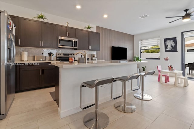 3431 W 109th Pl, Hialeah, FL 33018 - kitchen featuring stainless steel appliances, light countertops, a kitchen breakfast bar, dark brown cabinetry, and ceiling fan