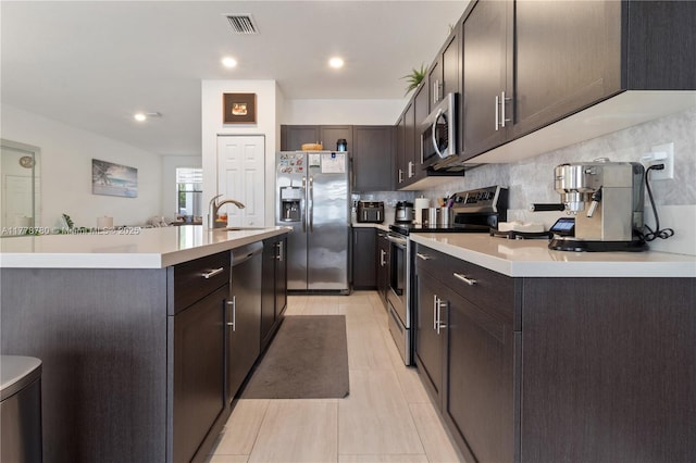 3431 W 109th Pl, Hialeah, FL 33018 - kitchen with stainless steel appliances, dark brown cabinetry, light countertops, a center island with sink, and recessed lighting