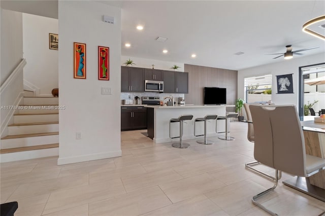3431 W 109th Pl, Hialeah, FL 33018 - kitchen with appliances with stainless steel finishes, open floor plan, a kitchen breakfast bar, ceiling fan, and light countertops