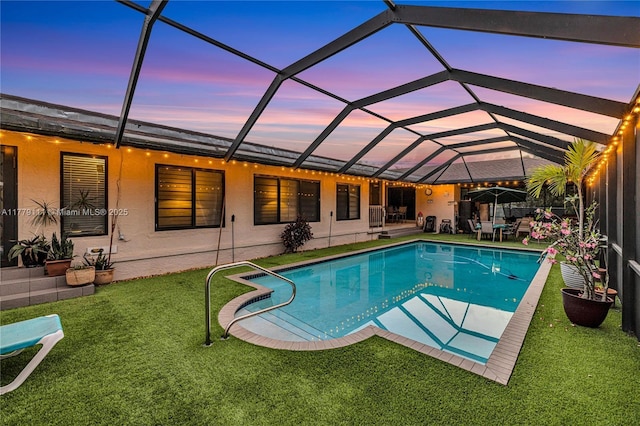 7801 SW 170th St, Palmetto Bay, FL 33157 - pool at dusk with a patio area, a lanai, a lawn, and an outdoor pool