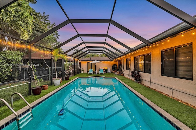 7801 SW 170th St, Palmetto Bay, FL 33157 - pool at dusk with a yard, an outdoor pool, and a lanai