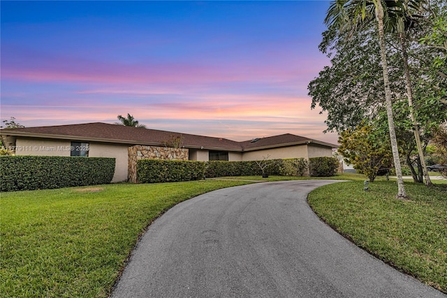 7801 SW 170th St, Palmetto Bay, FL 33157 - ranch-style home with curved driveway, stucco siding, stone siding, and a front lawn