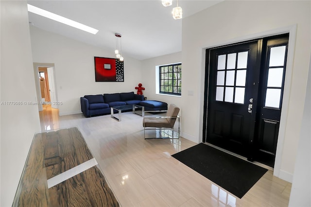 foyer entrance featuring baseboards and vaulted ceiling