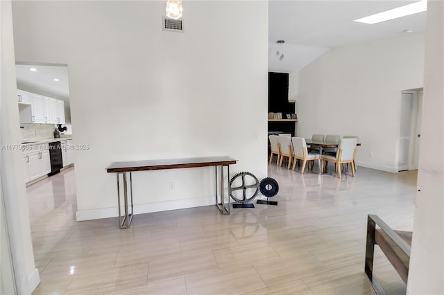 interior space featuring visible vents, baseboards, and vaulted ceiling
