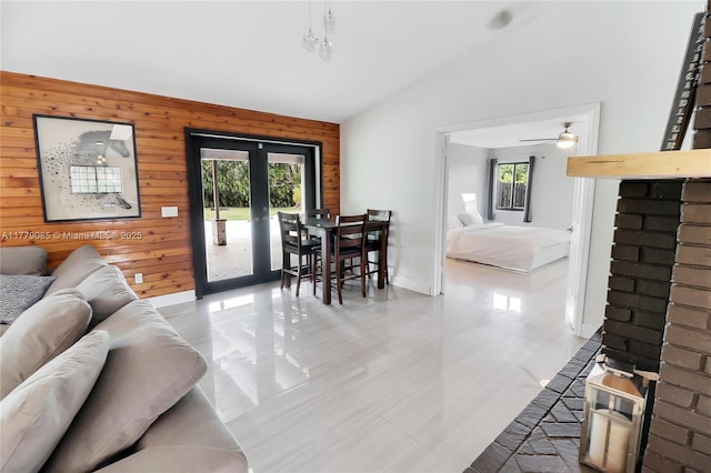 living room with a wealth of natural light, wood walls, and vaulted ceiling