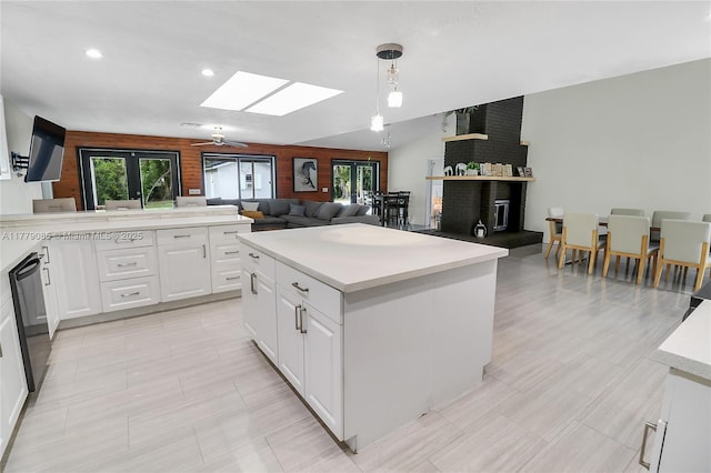 kitchen with light countertops, white cabinetry, dishwasher, and a healthy amount of sunlight