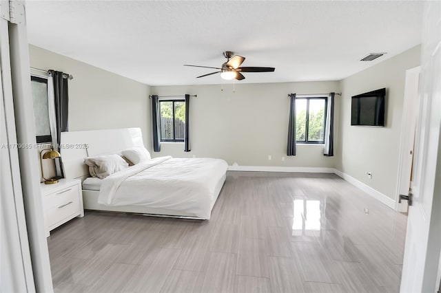 unfurnished bedroom with visible vents, multiple windows, baseboards, and a ceiling fan