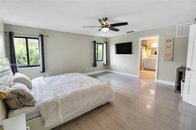 bedroom featuring ceiling fan, baseboards, visible vents, and connected bathroom
