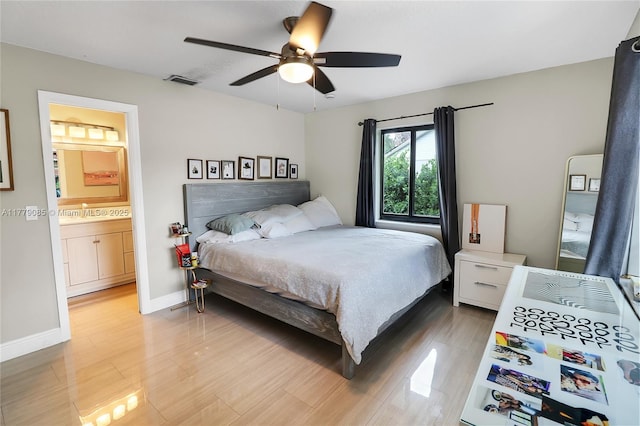 bedroom with visible vents, baseboards, ensuite bathroom, ceiling fan, and light wood finished floors