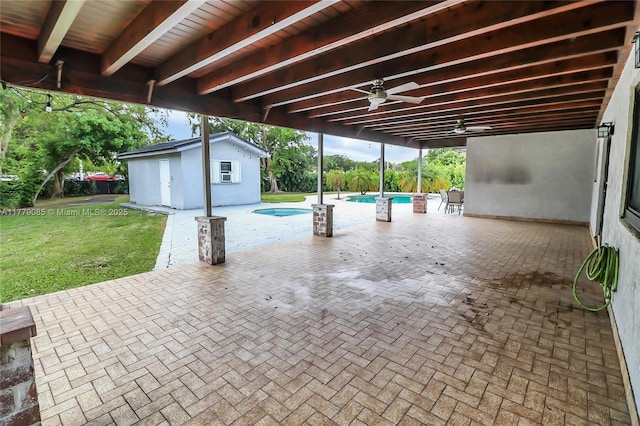 view of patio / terrace featuring an outdoor pool, an outbuilding, and a ceiling fan