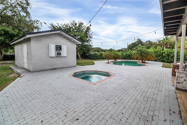 pool featuring a patio and an in ground hot tub